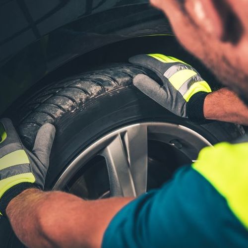 A Technician Checks a Tire. 