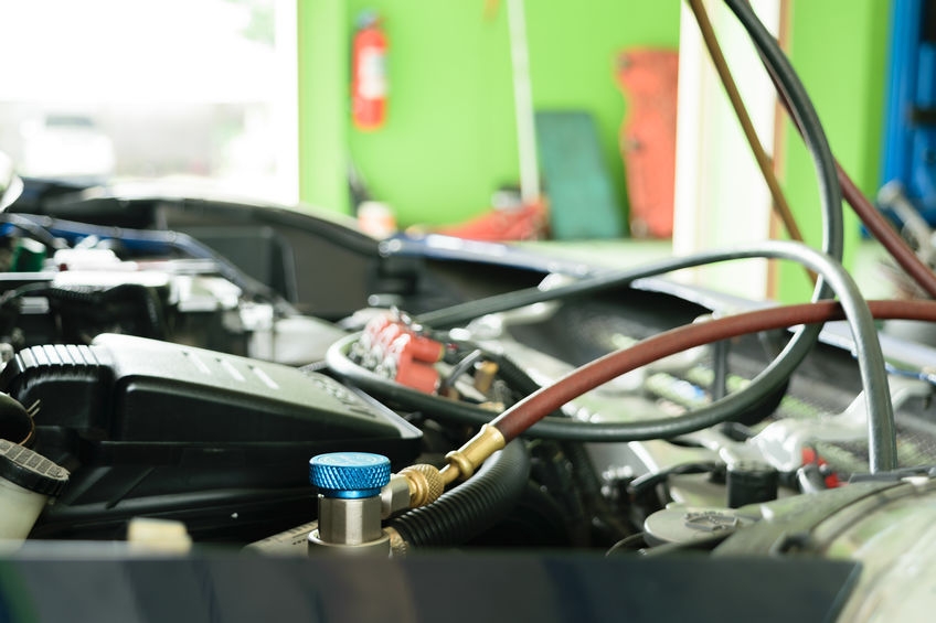 A Picture of a Car's Air Conditioner Being Filled Up.