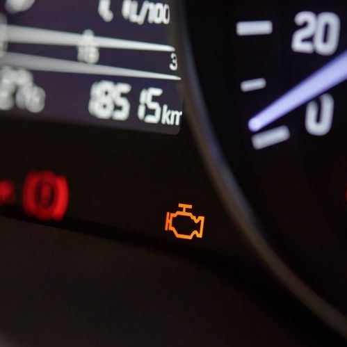Check engine icon on modern car dashboard close-up